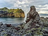 Rugged rock and cliffs along the coastline of the island of Heimaey, a part of an archipelago along the Southern coast of Iceland; Vestmannaeyjar, Southern Region, Iceland