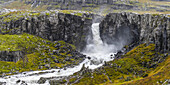 Wasserfall, der über eine Felsklippe fließt; Djupivogur, östliche Region, Island