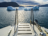 Icebergs in the water viewed from the back of a boat, off the coast of Greenland; Sermersooq, Greenland