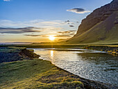 Schöner Sonnenaufgang über einem Fluss und einer üppigen Landschaft in Südisland; Skaftarhreppur, Südregion, Island