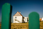 Weißes Haus durch grüne Zaunpfähle gesehen in Nordfrankreich; Ambleteuse, Pas de Calais, Frankreich.