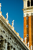 Detail eines Uhrenturms und Statuen entlang einer Dachlinie; Venedig, Veneto, Italien.