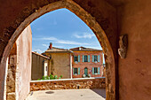 Blick durch einen Torbogen in Roussillon, Frankreich; Roussillon, Vaucluse, Frankreich.