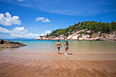 Alma Bay is one of the many beautiful beaches on Magnetic Island. A couple enjoys the refreshing beautiful clear waters; Magnetic Island, Queensland, Australia