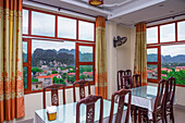 Views over the stunning countryside of Ninh Binh from a restaurant window, with its limestone mountains that have numerous caves and grottos covering the area; Ninh Binh, Vietnam