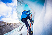 Reisende erkunden Neuseelands berühmten Franz-Josef-Gletscher. Blaues Eis, tiefe Gletscherspalten, Höhlen und Tunnel kennzeichnen das sich ständig verändernde Eis; Westküste, Neuseeland