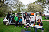 Setting up camp outside of a modified caravan camper; Bourton-on-the-Water,  Gloucestershire, England