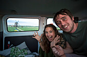 Travelers inside a camper van exploring North Holland searching for iconic windmills outside of Amsterdam Central along the journey to the coastal city of Egmond aan Zee; Holland
