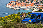 Travelers explore the surrounding cliffs above Dubrovnik with their car to catch the stunning views over the coastal city; Dubrovnik, Dubrovacko-neretvanska zupanija, Croatia