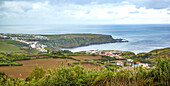 Malerischer Küstenblick auf Ackerland und typische weiß getünchte Gebäude mit Blick auf den Atlantischen Ozean; Azoren.