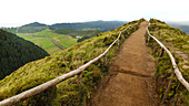 Pathway across the lush hills and farmland of the Sete Cidades within the the massive volcanic crater that lies in the center of Ponta Delgada; Sao Miguel Island, Azores