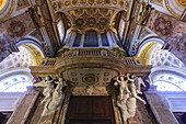 Church interior of Sant'Agnese in Agone, showing angel sculptures supporting a balcony from underneath with the ornate ceiling above; Rome, Lazio, Italy
