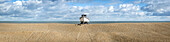 Wooden cabin boat tethered in the middle of the shingle beach at Dungeness along the Atlantic Coast; Dungeness, Kent, England, United Kingdom