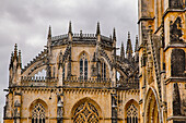 Close-up of the Gothic stonework and rooftop detail with a grey sky at the Batalha Monastery; Batalha, District of Leiria, Centro Region, Portugal
