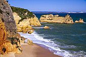 Die Brandung des Atlantiks am Dona Ana Strand mit seiner felsigen Sandsteinküste und den Felsen entlang der berühmten Algarveküste; Praia da Dona Ana, Lagos, Algarve Region, Portugal