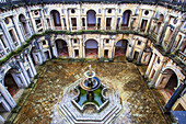 Blick auf den Innenhof mit mehreren Torbögen und Eingängen, die einen zentralen Wasserbrunnen umgeben, im Kreuzgang König Joao III. im Christuskloster, das im 12. Jahrhundert von den Tempelrittern gegründet wurde; Tomar, Bezirk Santaren, Provinz Ribatejo, Centro Region, Portugal.