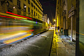 Unscharfe Straßenbahn, die durch die kopfsteingepflasterten Straßen der historischen Stadt Lissabon bei Nacht fährt; Lissabon, Lisboa, Portugal