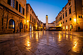 Lichtreflexionen auf den Steinplatten des Luza-Platzes in der Altstadt, Blick auf den Uhrenturm in der Abenddämmerung; Dubrovnik, Dalmatien, Kroatien.