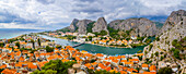 Overview of Omis, the historical town situated at the mouth of the Cetina River with its rocky canyons looking out to the Adriatic Sea; Omis, Dalmatia, Croatia
