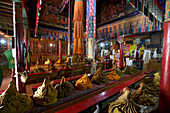 Monastic robes piled in rows on benches in the Prayer Hall at Likir Monastery in the Himalayan Mountains of Lakakh, Jammu and Kshmir; Likir, Ladakh, India