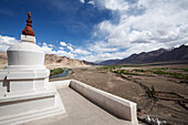 Close-up of the concrete, rooftop walkway at the Stakna Monastery with its whitewashed Buddhist stupa (known as chortens in Tibetan Culture) and the view from above the Indus Valley, through the Himalayan Mountains of Ladakh, Jammu and Kashmir; Stakna, Ladakh, India