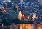 Die im 20. Jahrhundert restaurierte und in der Abenddämmerung beleuchtete St.-Nikolaus-Kirche im unteren Hof der alten Narikala-Festung in der Hauptstadt Tiflis; Tiflis, Georgien.