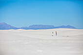 Tourists exploring the beautiful, plain white sands of the dunefields at the White Sands National Park; White Sands National Park, New Mexico, United States of America