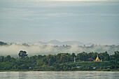 Morgennebel steigt über einer Dorfstupa am dschungelbedeckten Ufer des Ayeyarwady (Irrawaddy) Flusses auf; Ländlicher Dschungel, Kachin, Myanmar (Burma)