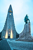 The Hallgrimskirkja illuminated, Lutheran cathedral with a statue of the famous explorer Leif Erikson in front that predates the church, the first European to reach America; Reykjavik, Capital Region, Iceland