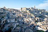 Cityscape of the mountaintop town of Sassi di Matera and its ancient cave dwellings with the bell tower of the Matera Cathedral overlooking the city; Matera, Basilicata, Italy