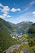 The tourist town of Geiranger surrounded by forested mountains at the head of the Geirangerfjord in Sunnmore; Geirangerfjord, Stranda, Norway