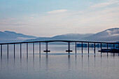 Silhouette der Tromso-Brücke über die Tromsoysundet-Straße zwischen Tromsdalen auf dem Festland und der Insel Tromsoya in der Hafenstadt Tromso nördlich des Polarkreises an der Westküste Norwegens; Tromso, Troms og Finnmark, Norwegen