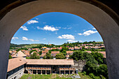 Blick auf die Stadt und die mittelalterliche Burg Cetatea Bethlen von Racos durch einen Torbogen; Racos, Siebenbürgen, Rumänien.