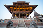 Statuen von knienden Elefanten, die einen Ziegel- und Holztempel auf dem Durbar-Platz in der alten Stadt Patan oder Lalitpur bewachen, der zwischen dem 16. und 18. Jahrhundert von den Newari Hindu Mallas im Kathmandu-Tal erbaut wurde; Patan (Lalitpur), Kathmandu-Tal, Nepal.