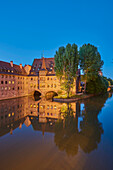 Die Pegnitz fließt durch Nürnberg zur blauen Stunde mit dem Heilig-Geist-Spital in der Altstadt; Franken, Bayern, Deutschland.