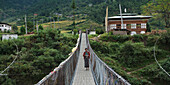 A Woman Walking On A Suspension Bridge; Punakha District Bhutan