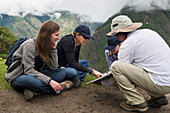 Touristen lesen aus einem Führer in der verlorenen Stadt der Inka; Machu Picchu Peru