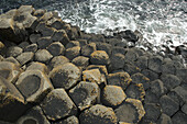 Schwarze Basaltsäulen, die aus dem Meer ragen, Giant's Causeway, Nordirland, Vereinigtes Königreich