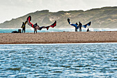 Menschen, die sich am Strand von Punta Paloma auf das Kitesurfen vorbereiten; Tarifa Cadiz Andalusien Spanien