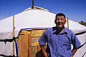 Mongolia, Nomadic Community; Ger Ranch, Local man standing in front of unique house