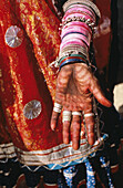 Indien, Rajasthan, Nahaufnahme eines Dorfbewohners, handbemalt mit roten Mustern, Schmuck und roter Kleidung.