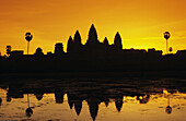 Kambodscha, Siem Reap, Angkor Wat, Silhouette des Tempels bei Sonnenaufgang, Reflexionen auf der Wasseroberfläche, ornamentierter Himmel