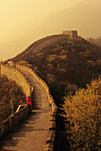 China, Mu Tian Yu, Die Große Mauer mit nebligem gelben Himmel, Fahnen entlang der Mauer