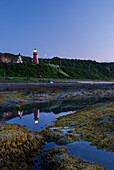 Red Lighthouse Reflecting In A Beach Pool; La Martre Quebec Canada