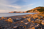 Sunrise On A Beach And Cliffs Along The Water; Quebec Canada