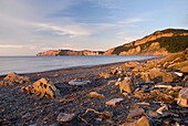 Sonnenaufgang an einem Strand und Klippen entlang des Wassers; Quebec Kanada