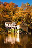 Ein Haus entlang des Flusses, das sich im Herbst im Wasser spiegelt; Durham England