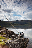 Ein Boot im Wasser, das sich mit der Seite gegen das Ufer lehnt; Argyll Schottland