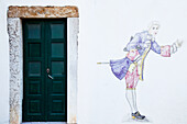 Painting Of An Historical Figure On A White Wall Beside A Door; Faro Algarve Portugal
