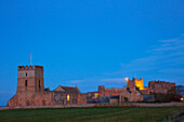Bamburgh Castle beleuchtet in der Abenddämmerung; Bamburgh Northumberland England